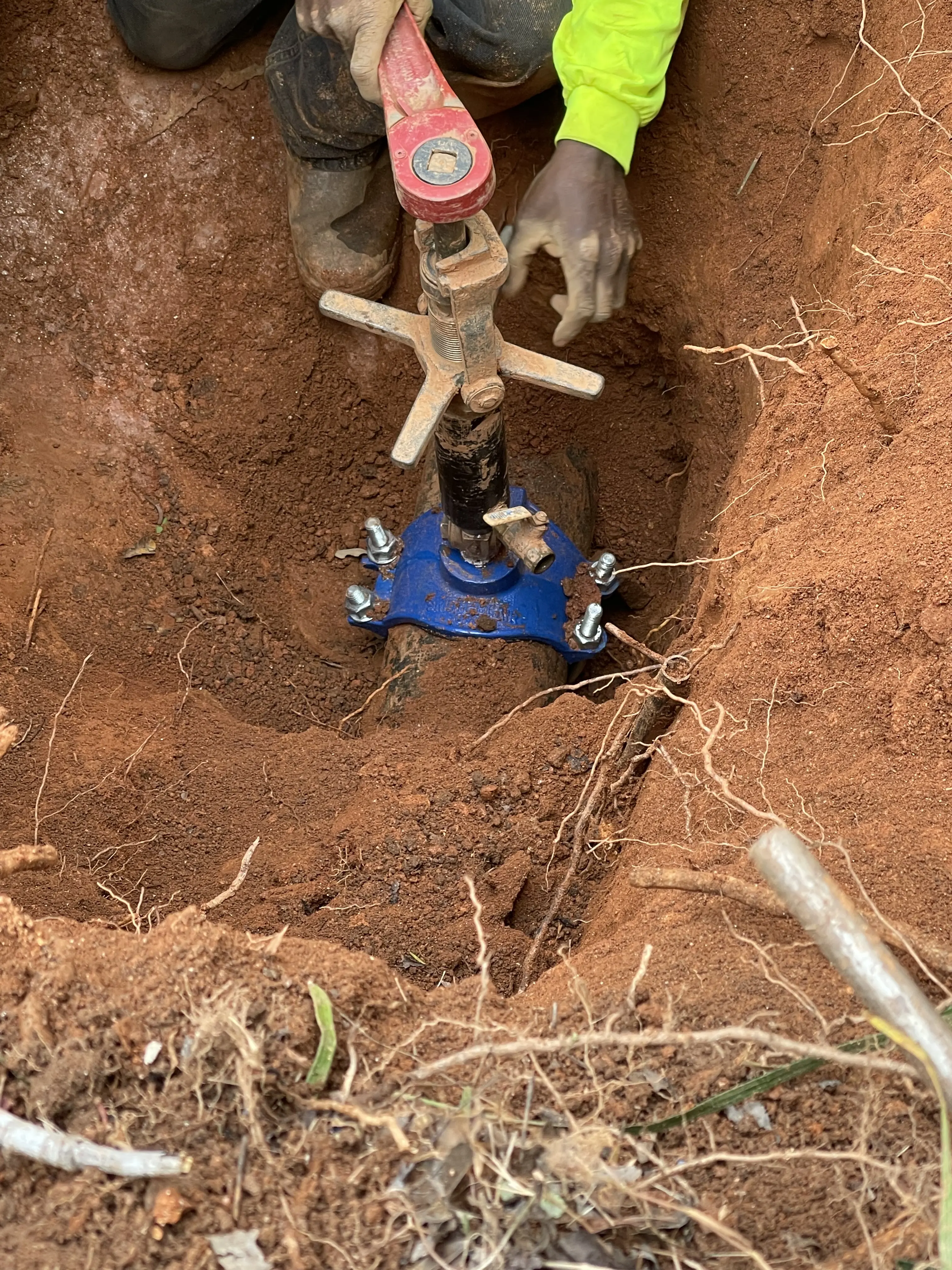 Worker using a tool in a deep hole for construction.